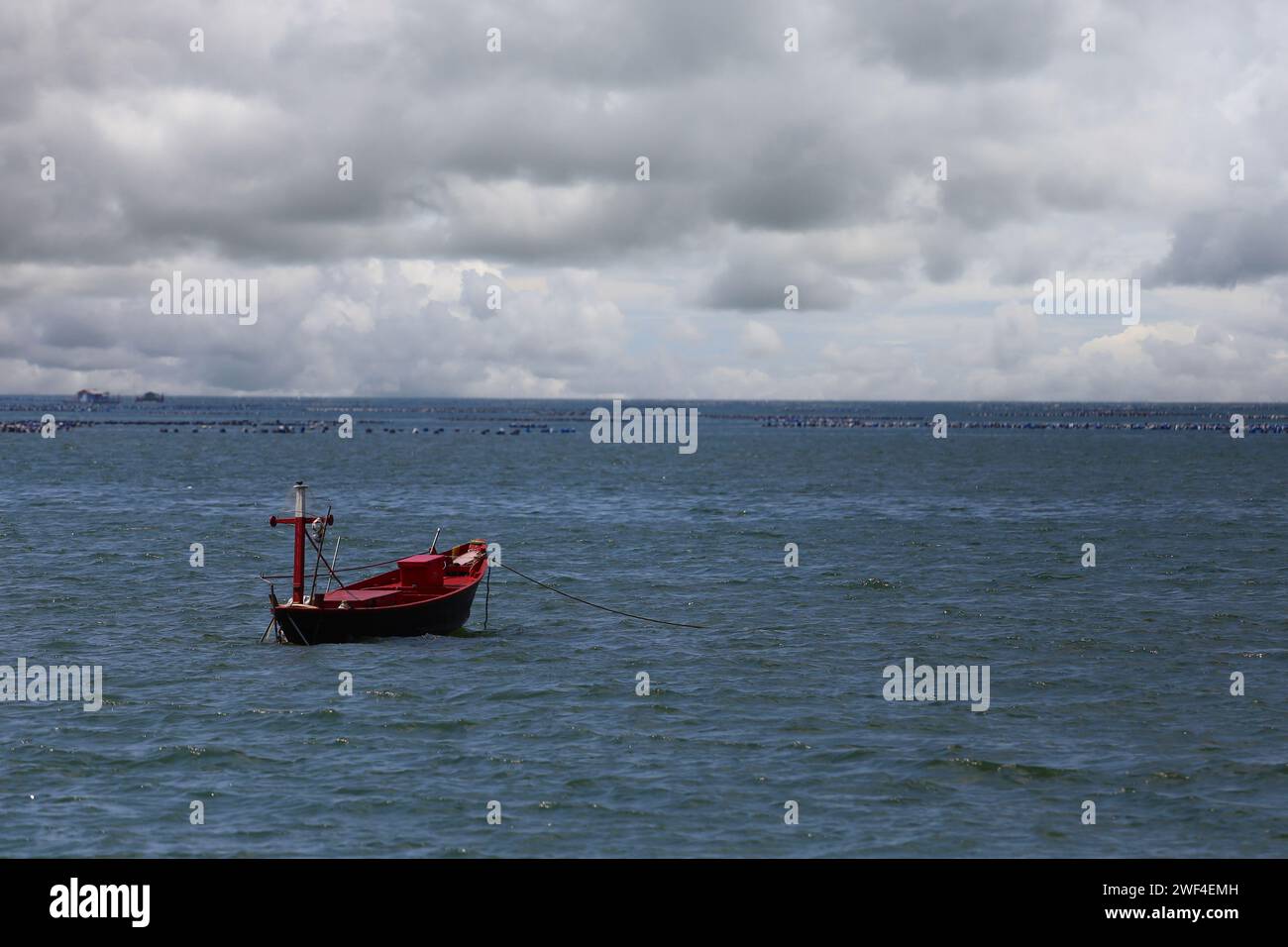A Fishing Boat Floats In The Middle Of The Sea And The Sky Has White a-fishing-boat-floats-in-the-middle-of-the-sea-and-the-sky-has-white