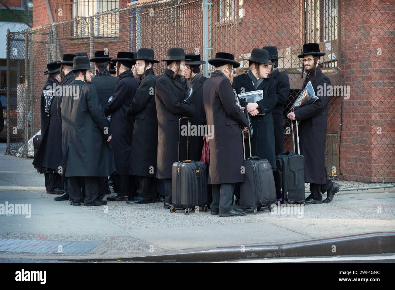 A group of orthodox Jewish young men wait for a bus to transport them to classes on the other side of Brooklyn. In Williamsburg. Stock Photo