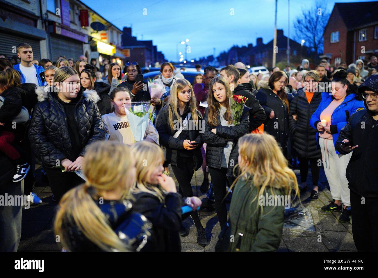 People take part in a vigil near to the scene in south Bristol where two teenage boys, aged 15 and 16, died after a stabbing attack by a group of people who fled the scene in a car. Picture date: Sunday January 28, 2024. Stock Photo