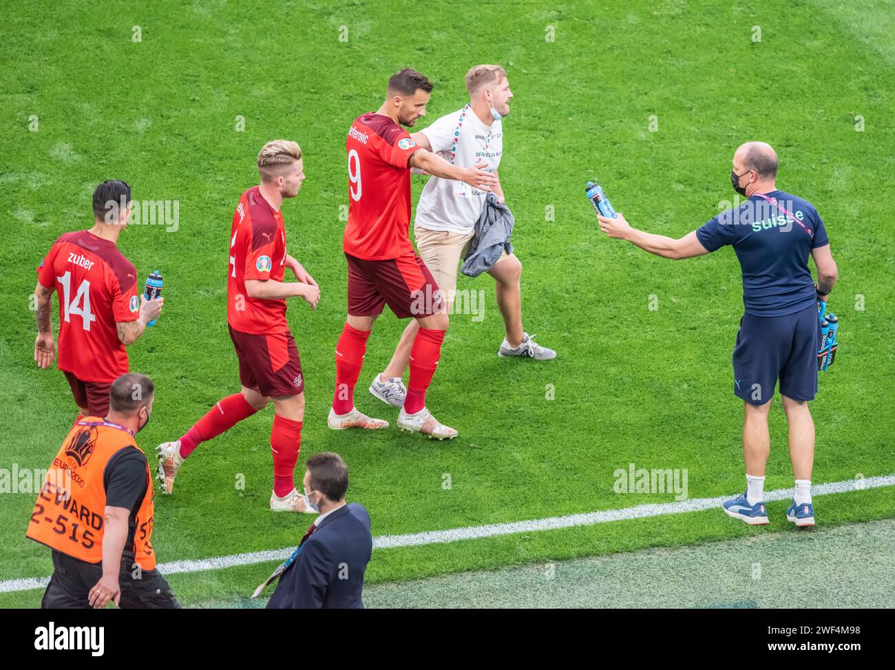 Saint Petersburg, Russia – July 2, 2021. Switzerland players Steven Zuber, Nico Elvedi and Haris Seferovic escoring a pitch invader from the pitch dur Stock Photo
