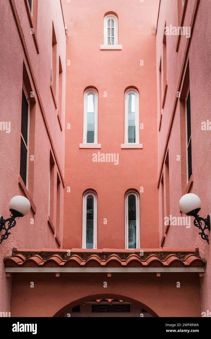 Peach colored vintage building detail exterior with arched windows and doors in the color of peach fuzz. Stock Photo