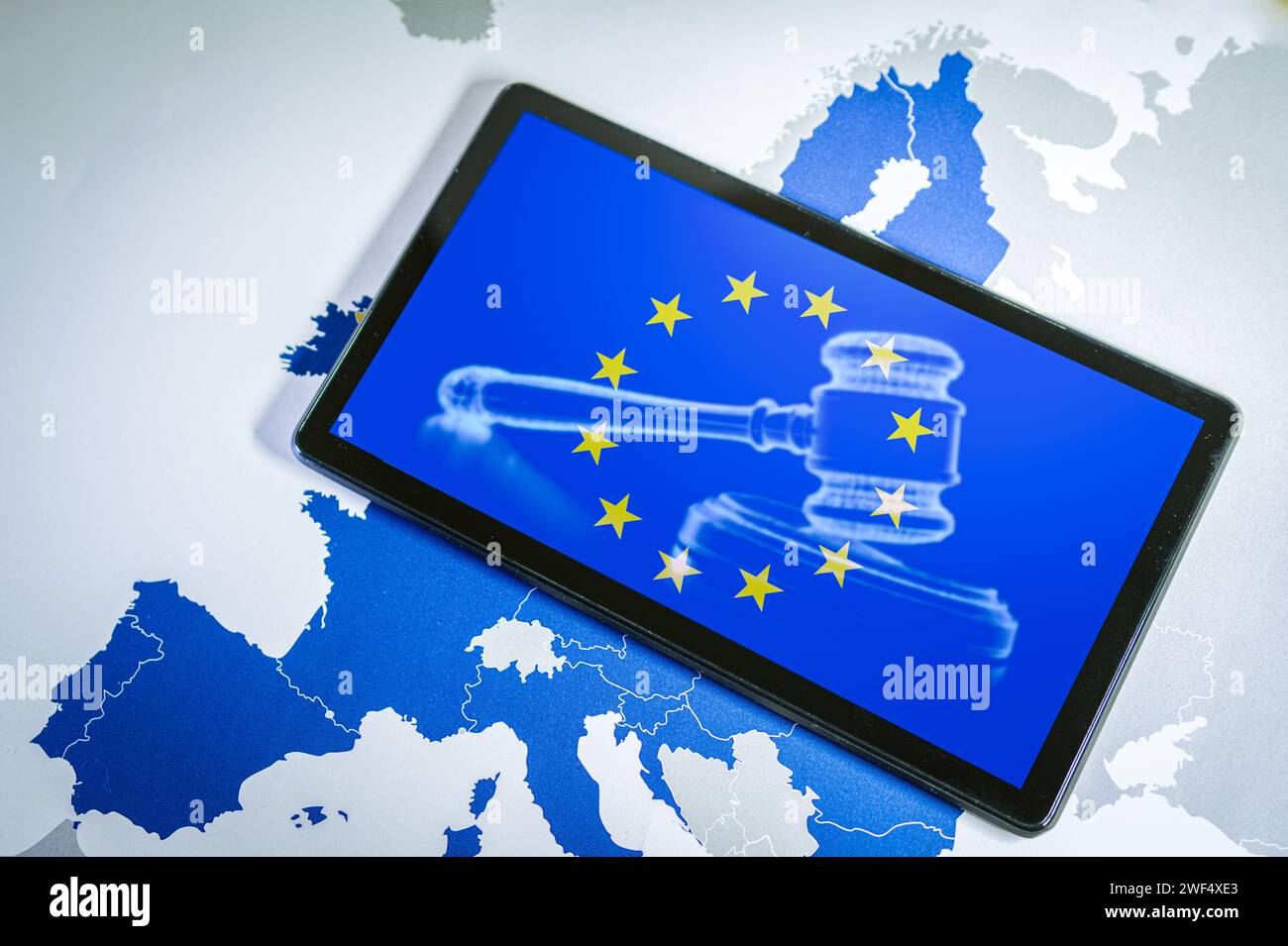 EU Flag with gavel and sound block on smartphone screen over a Eu map. Stock Photo