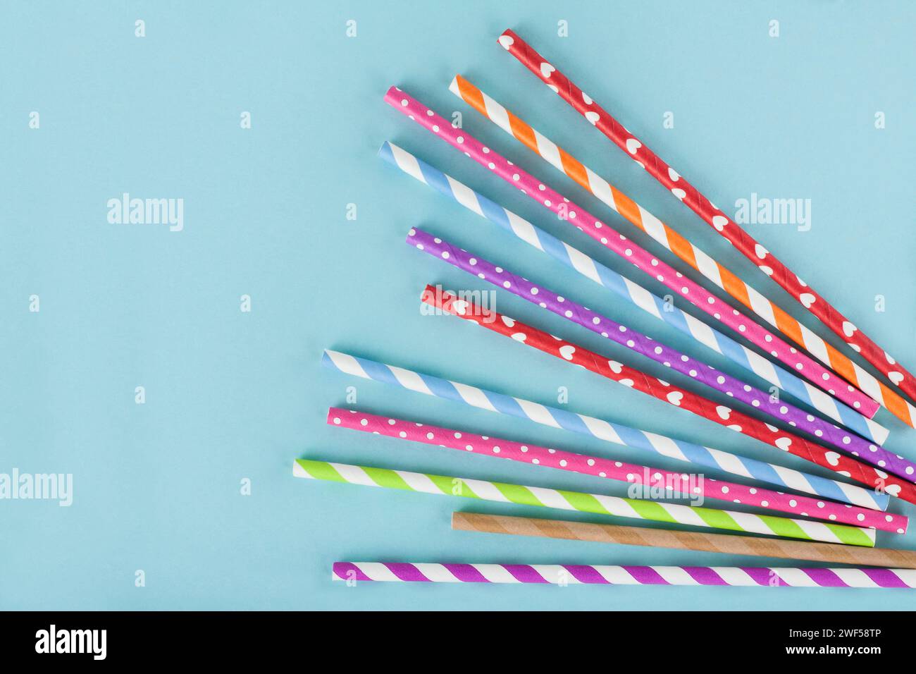 Different colordul paper straws on blue background Stock Photo