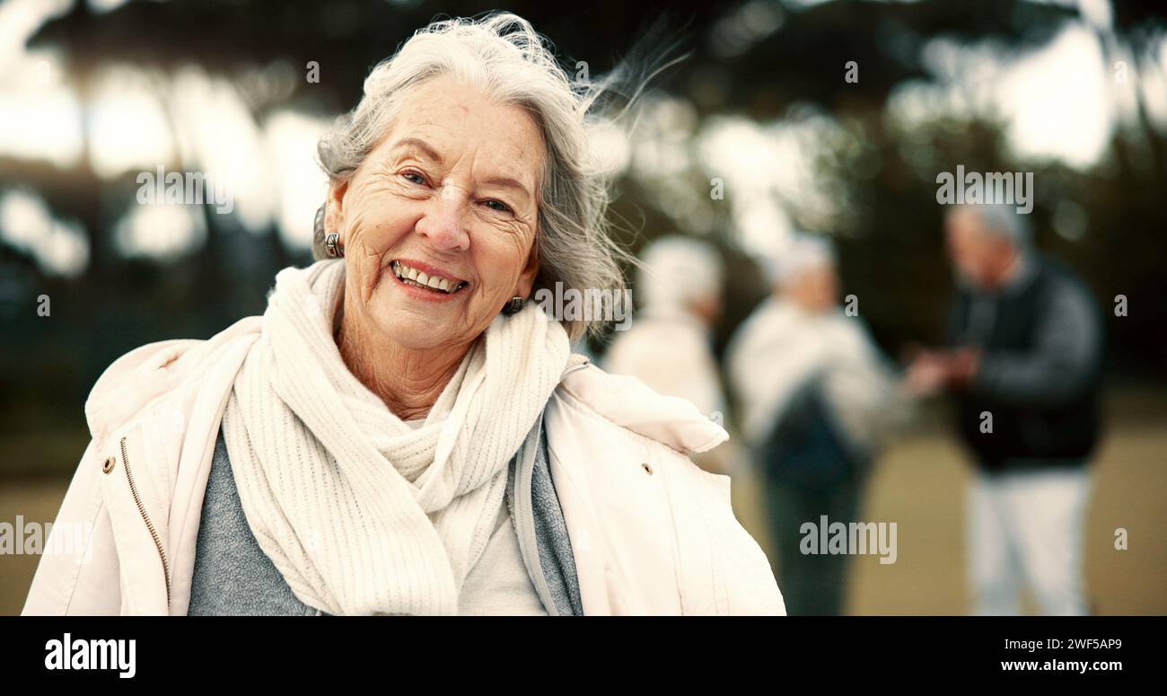 Face, senior woman and funny at park on vacation, holiday or travel in winter. Portrait, happy and elderly person in the countryside, nature or garden Stock Photo