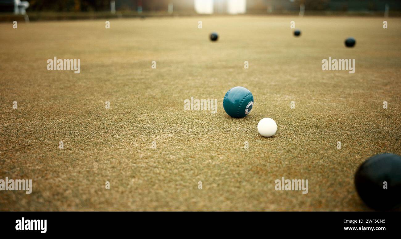 Green, balls and game of lawn bowling on grass, field or pitch in match or competition of outdoor bowls. Ball, moving and sport tournament at bowlers Stock Photo