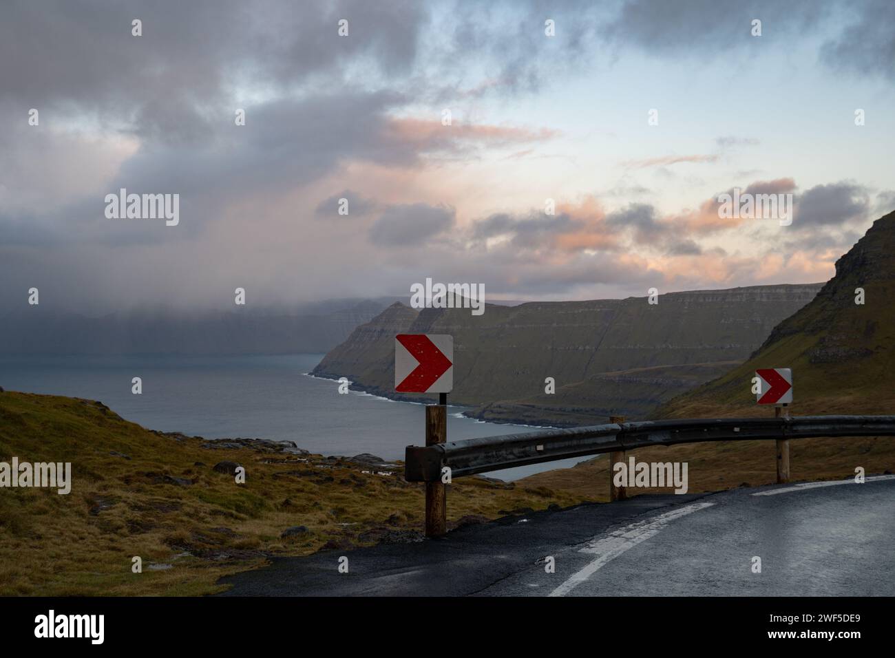 Two road signs on a curved path, offering stunning views of the landscape Stock Photo