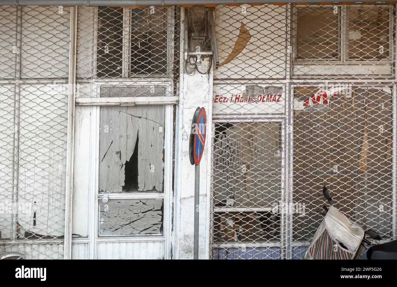 Shabby closed business store front building, metal grid closed with holes Sanliurfa Turkey Stock Photo