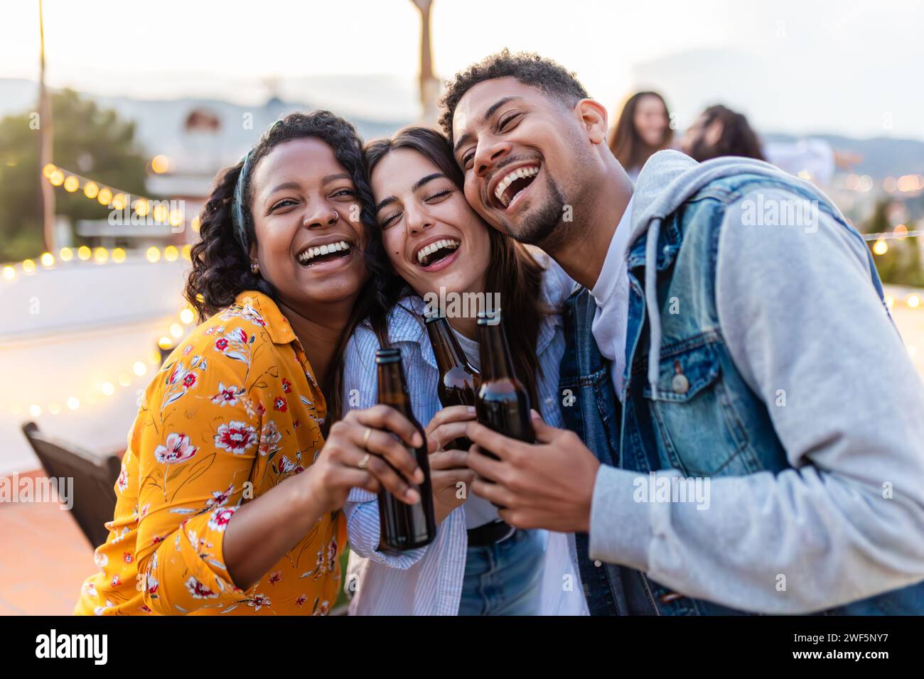 Happy young friends drinking beer in a terrace while enjoying summer party Stock Photo