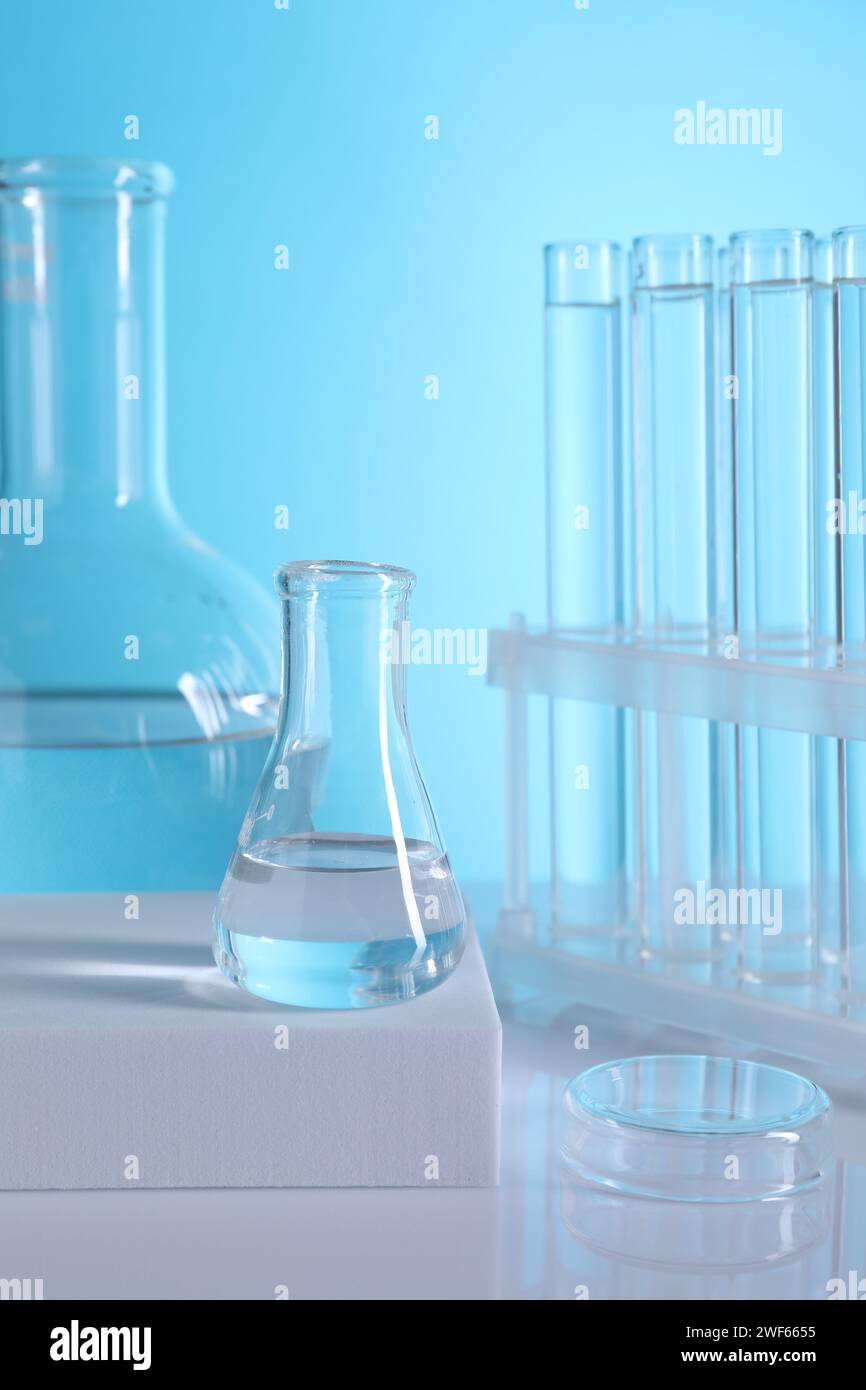 Laboratory analysis. Glass test tubes and flasks on table against light ...