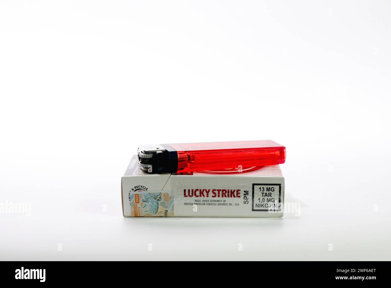 Packs of British American Tobacco Lucky Strike cigarettes with red lighter  isolated on white background Stock Photo