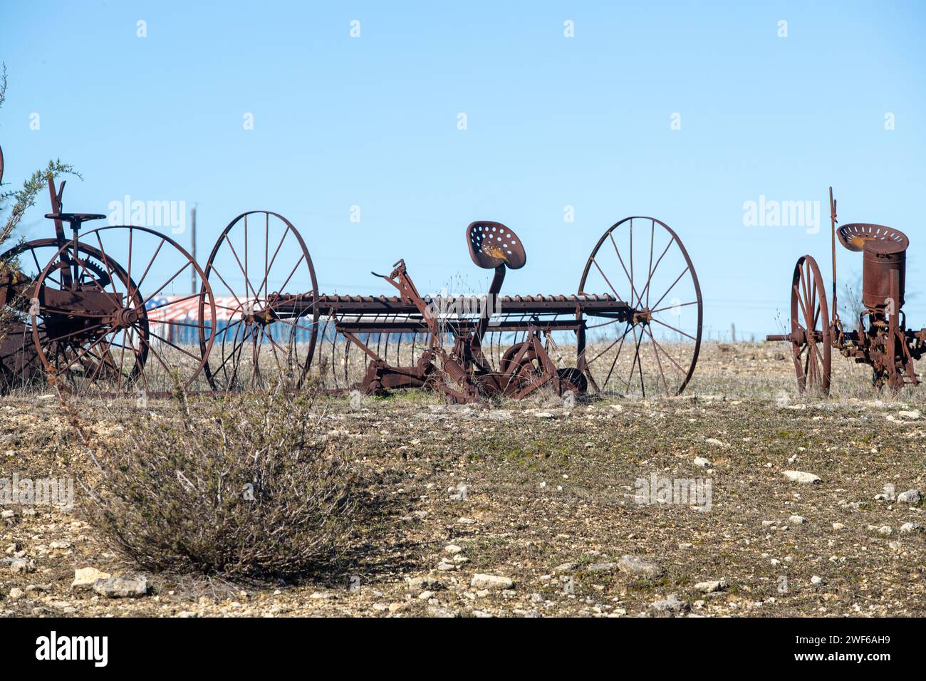 Abandoned, rusting vintage farm equipment in an open field Stock Photo