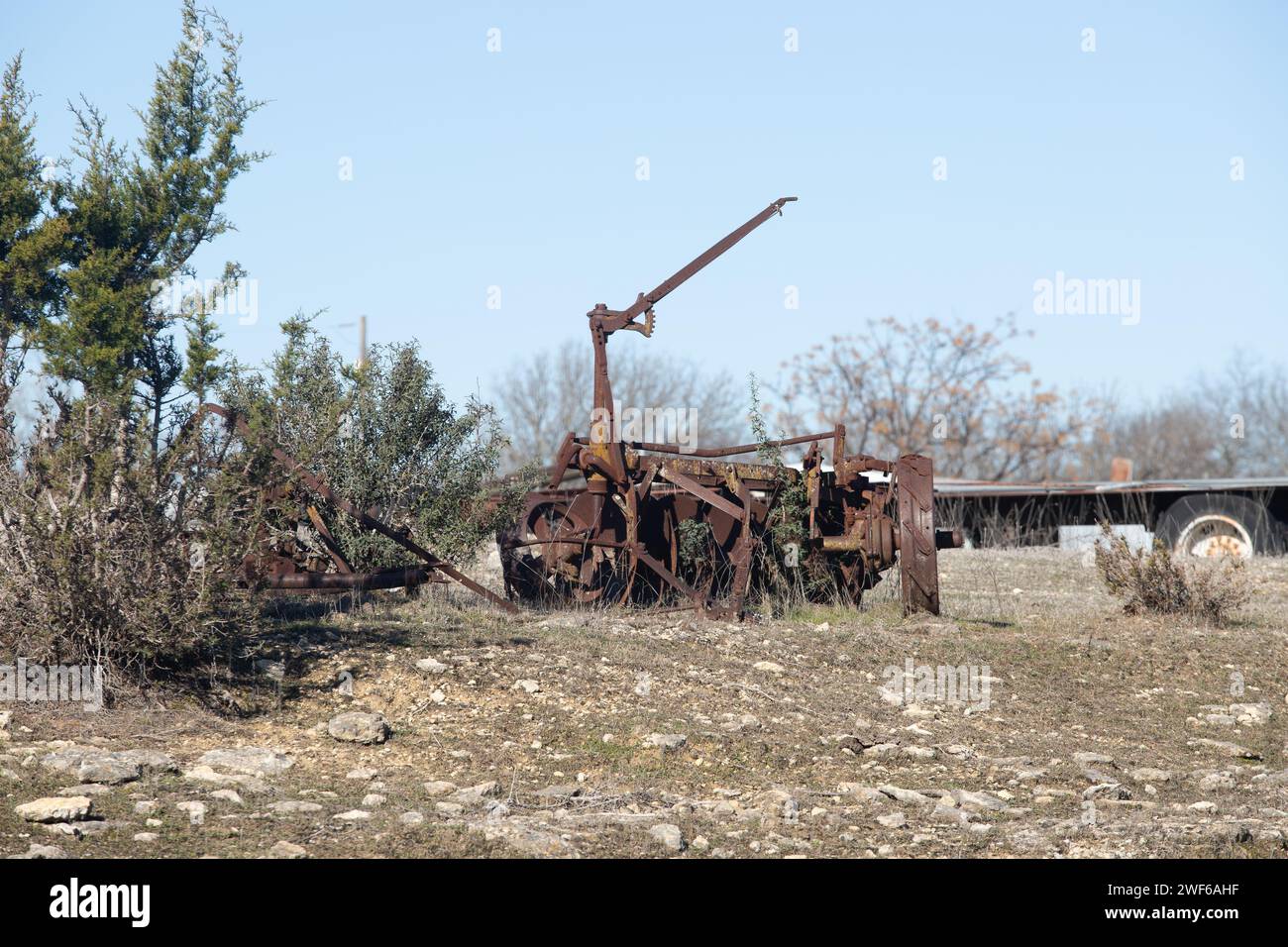 Abandoned, rusting vintage farm equipment in an open field Stock Photo
