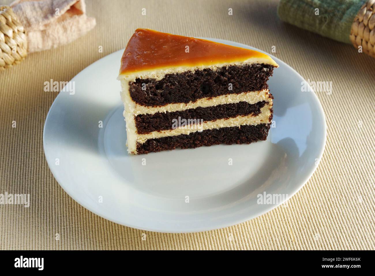 Piece of cake sits elegantly on a pristine white plate, offering a mouthwatering treat. Stock Photo