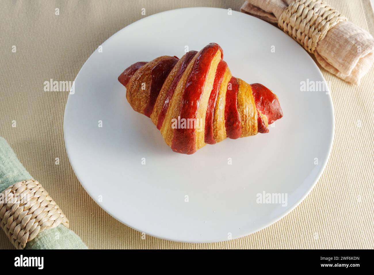 Croissant vibrant piece of fruit, a succulent crimson strawberry, creating an ethereal and evocative composition. Stock Photo