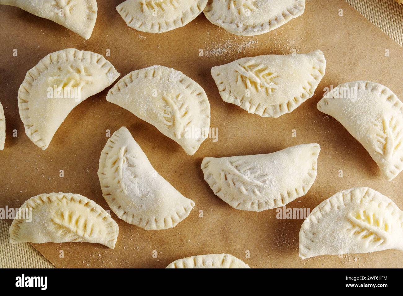 Variety of beautifully crafted dumplings artfully assembled on a wooden cutting board. Stock Photo