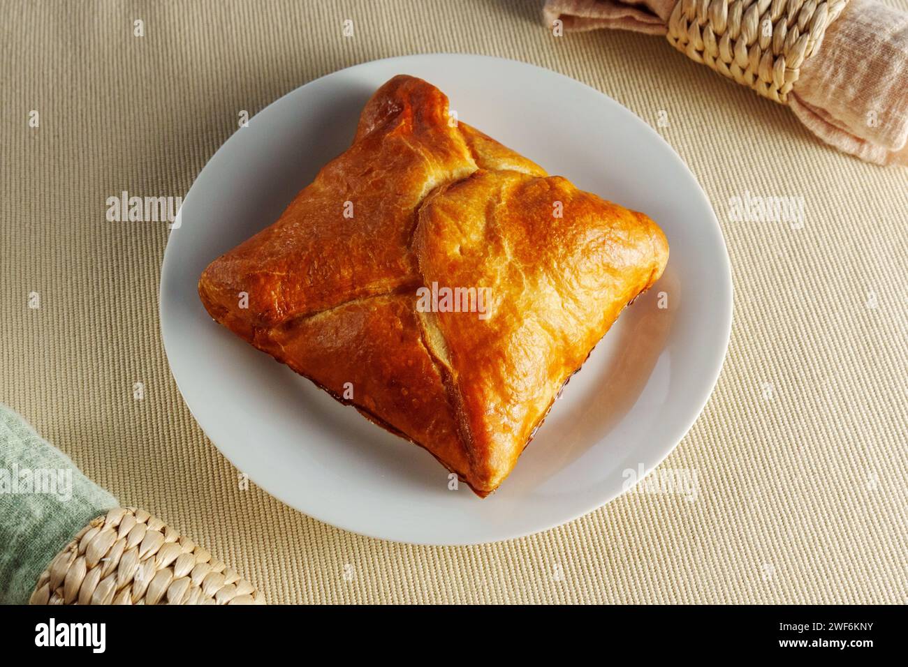 Delicate Delights: A Flaky Puff Pastry Placed Elegantly on a Gleaming White Plate Stock Photo
