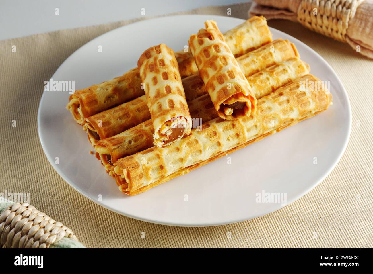 Mouthwatering stack of delicious golden waffles sits atop a pristine white plate placed elegantly on a table. Stock Photo