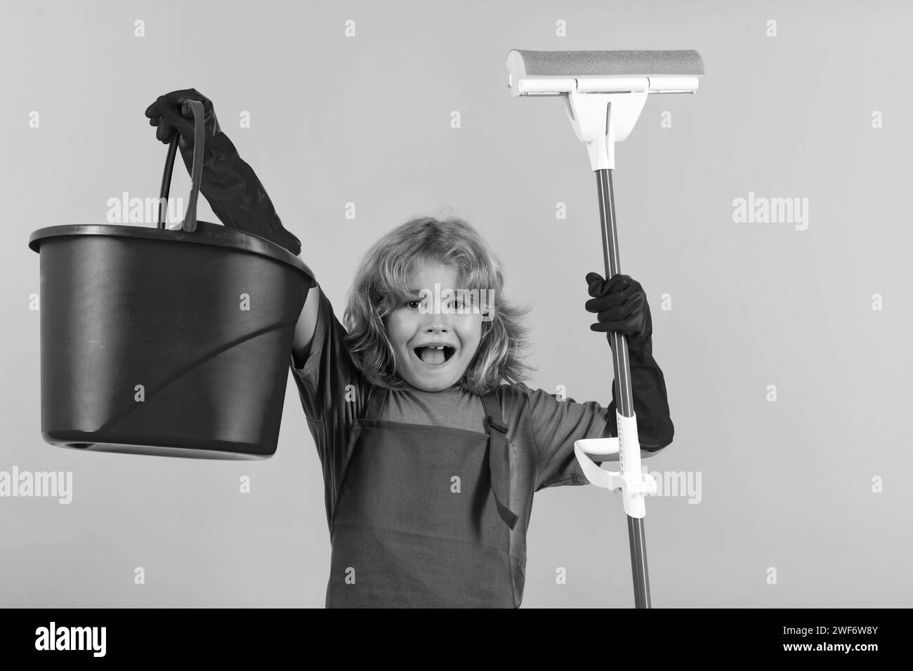 Cleaning house. Studio isolated portrait of child mopping house, cleaning home. Detergents and cleaning accessories. Cleaning service. Little boy Stock Photo