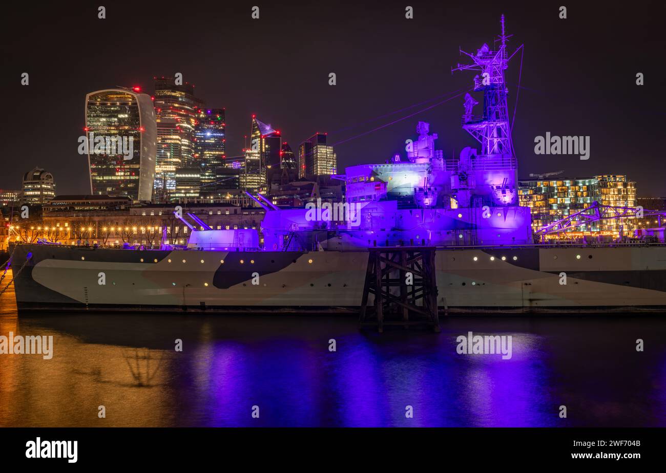 London. UK-01.27.2024. Close up of the HMS Belfast battleship museum at night with skyscraper from the City of London in the background. Stock Photo