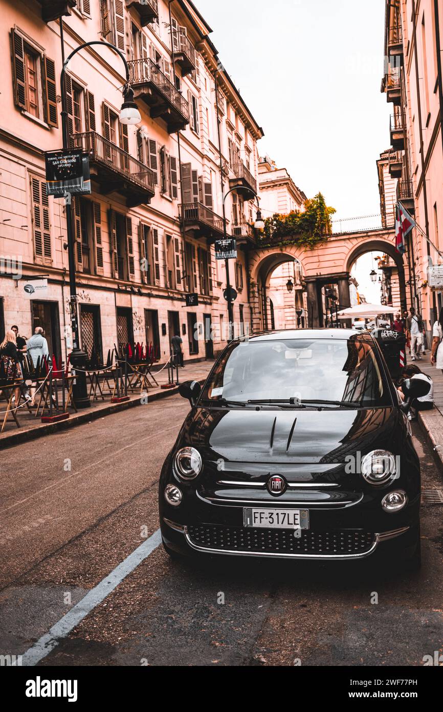 A timeless Fiat 500 car stands out on the cobblestone streets of Turin ...