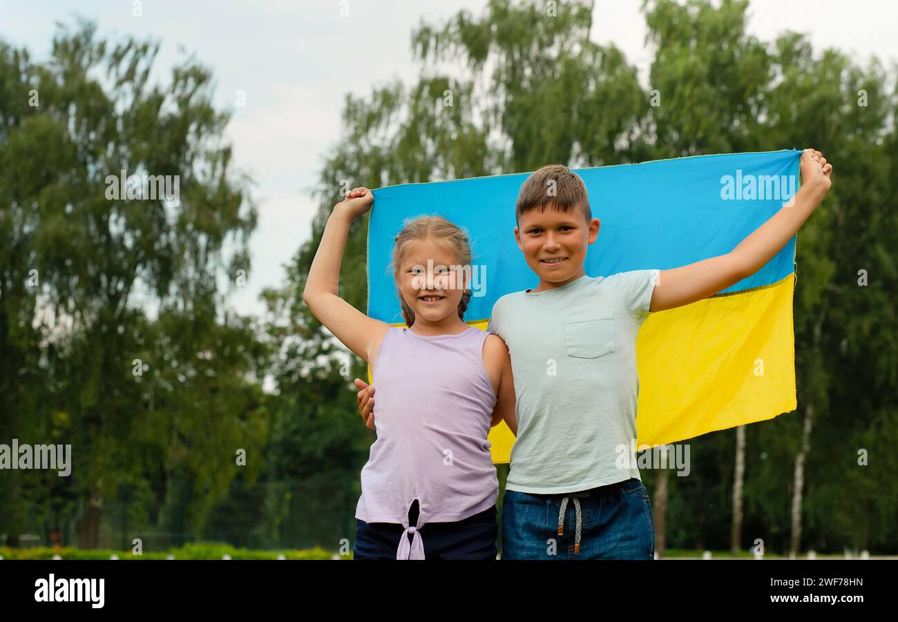 Ukrainian children boy and girl with yellow and blue flag of Ukraine in stadium. Ukraine's Independence Flag Day. Constitution day. flag symbols of Uk Stock Photo