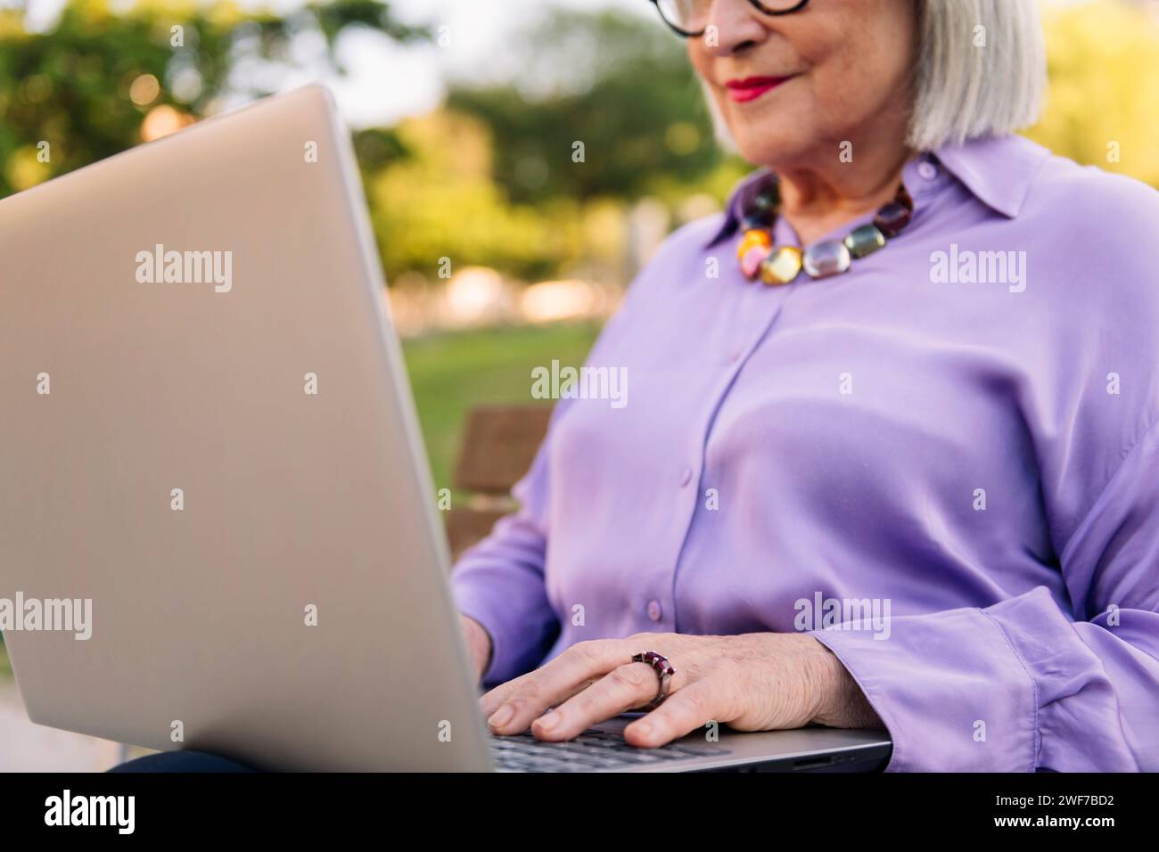 unrecognizable senior woman typing on laptop Stock Photo
