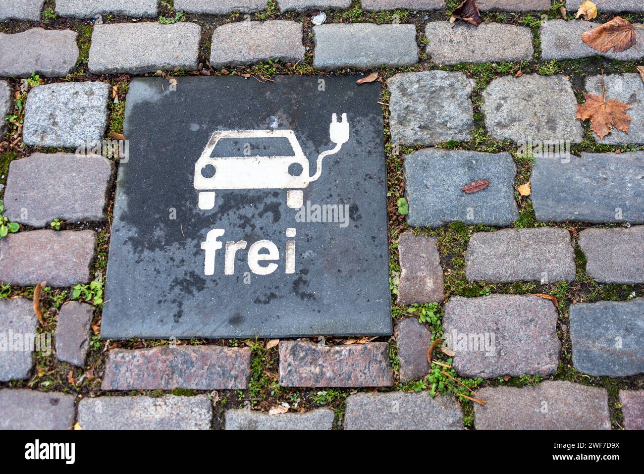 Schild auf dem Pflaster eines Parkplatzes zur Reservierung für PKW mit Batterieantrieb *** Sign on the pavement of a parking lot to reserve a space for battery-powered cars Stock Photo