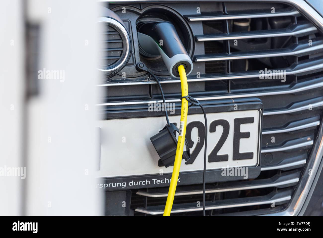 Auto elektrisch betrieben an einer Ladestation an einem Parkplatz in der Innenstadt *** Car powered by electricity at a charging station in a parking lot in the city center Stock Photo