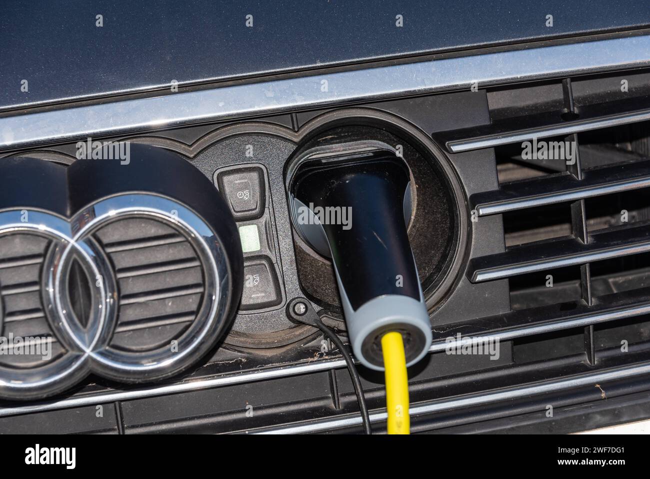 Auto elektrisch betrieben an einer Ladestation an einem Parkplatz in der Innenstadt *** Car powered by electricity at a charging station in a parking lot in the city center Stock Photo