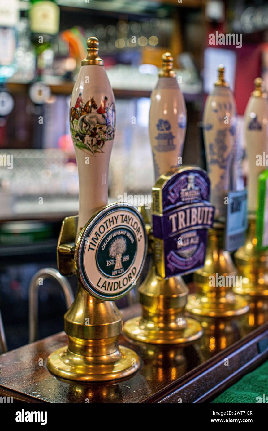 Beer pump handles in a traditional pub in London , UK Stock Photo