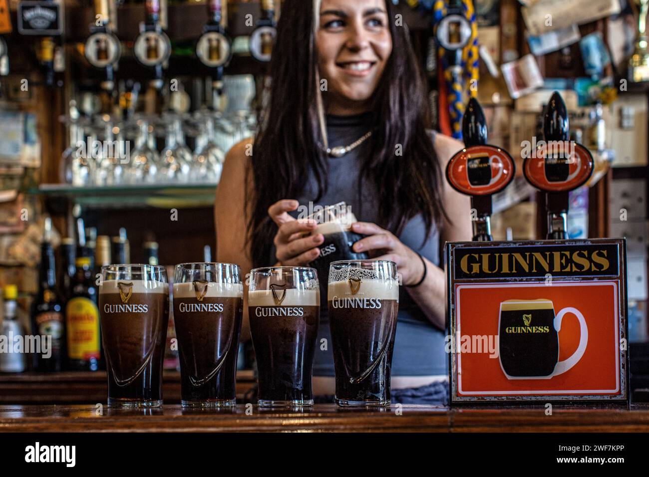 Barmaid in Irish pub The Auld Shillelag pulling Guinness in Stoke Newingtion, London , Uk Stock Photo
