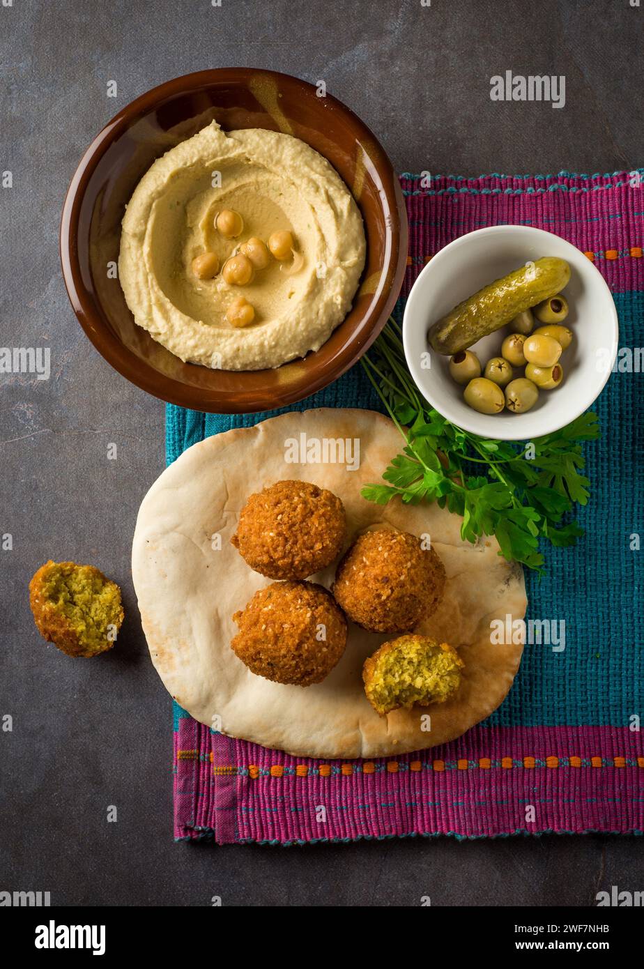 Falafel with hummus, pita bread and pickle. Top view of authentic Middle Eastern cuisine. Stock Photo