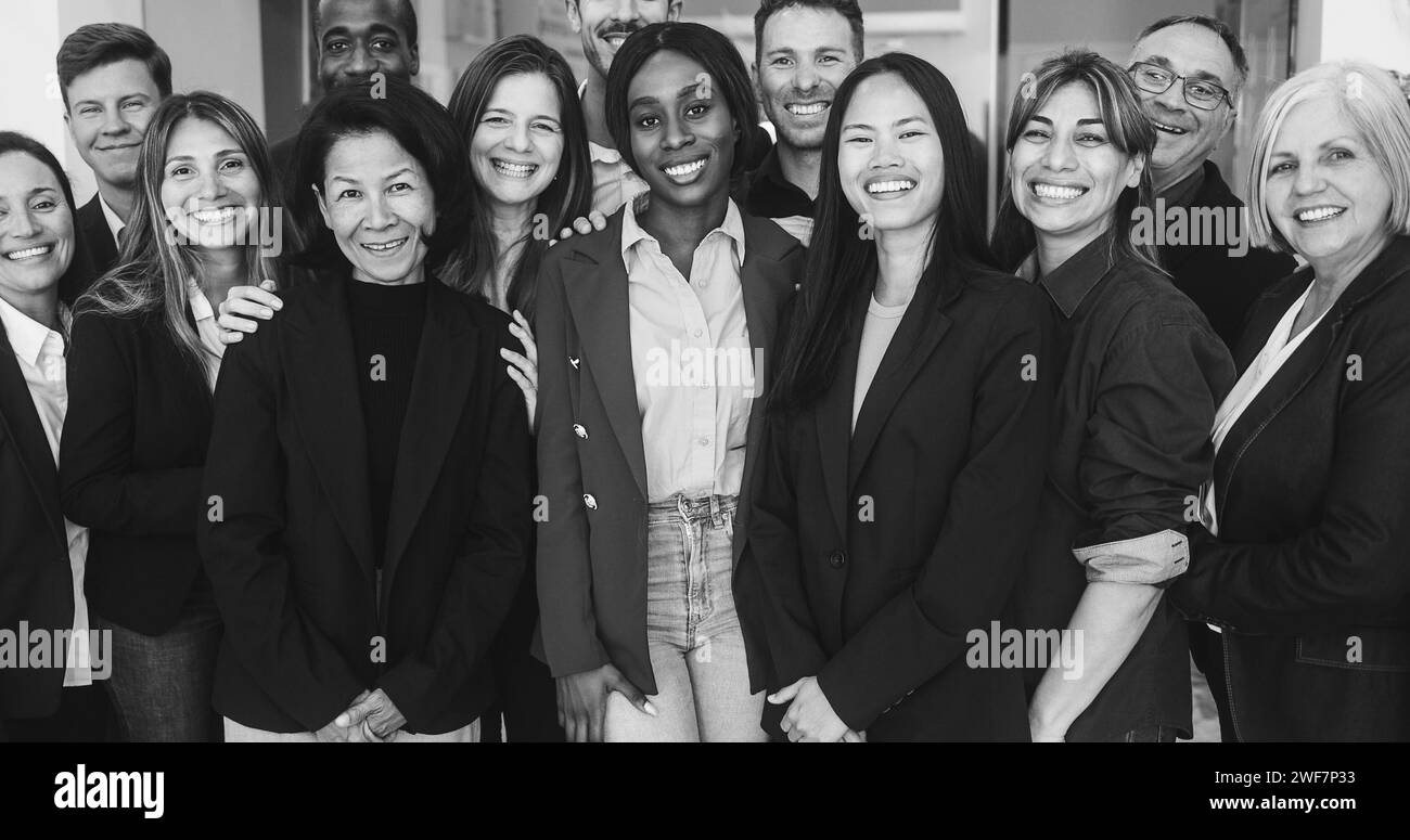 Multigenerational workers smiling in front of camera inside business office - Multiracial, job employees, entrepreneur and teamwork concept - Main foc Stock Photo