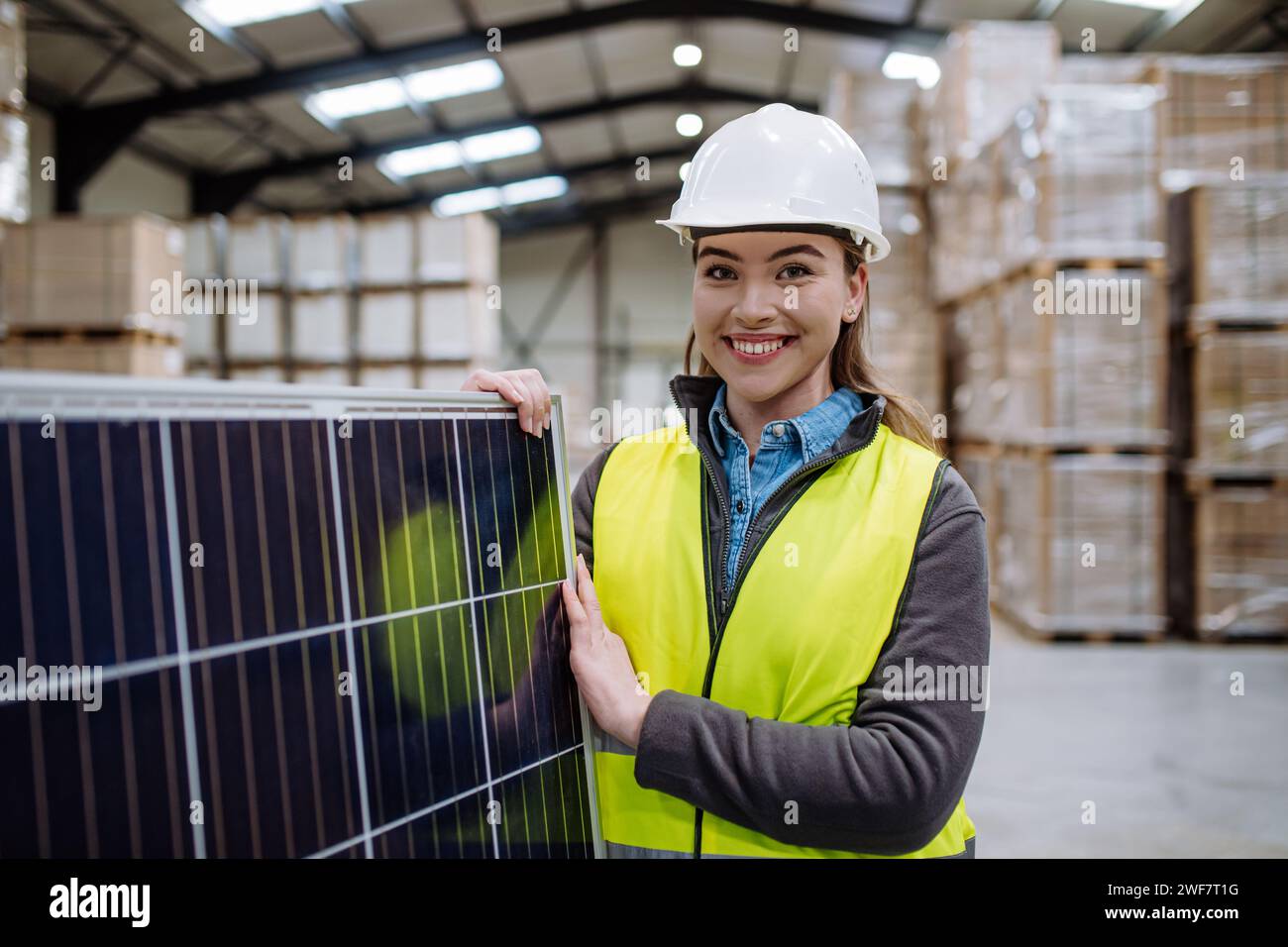 Female worker carrying solar panel in warehouse, factory. Solar panel ...