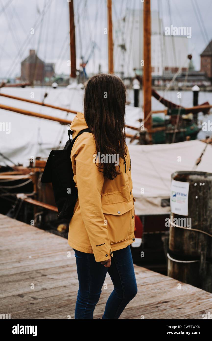 Urban adventure: Woman in yellow explores the picturesque harbor Stock Photo