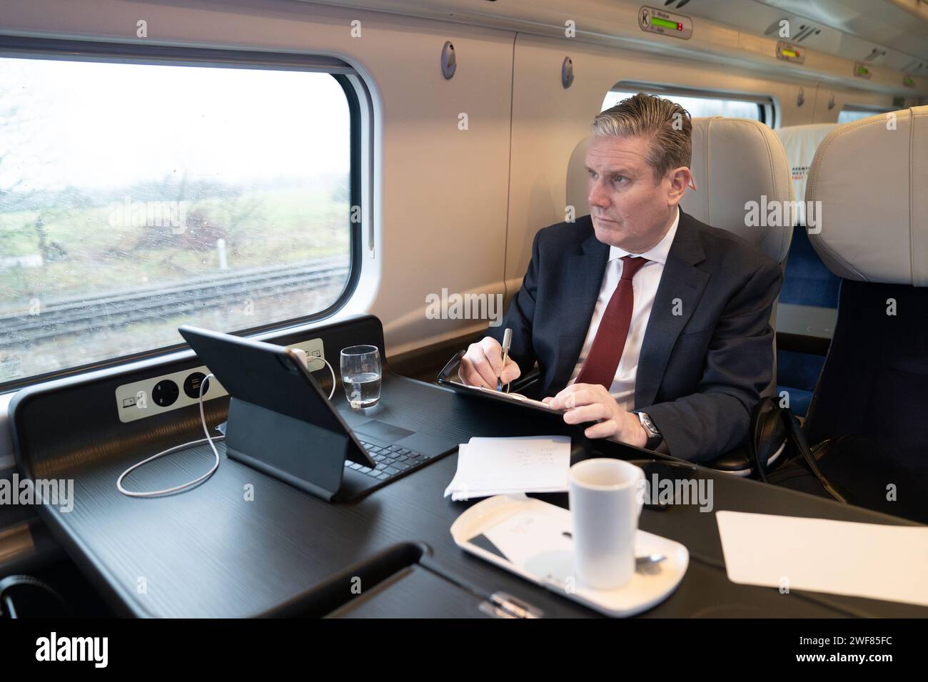 Labour leader Sir Keir Starmer travels by train to meet with executive chairman of Iceland supermarket, Richard Walker who has given his backing to Labour, saying the party was the 'right choice' for business and voters. Picture date: Monday January 29, 2024. Stock Photo