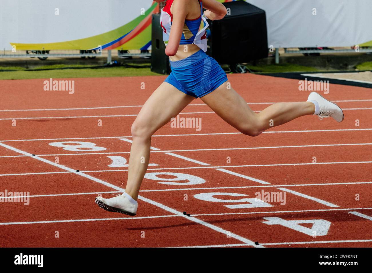 female runner para-athlete on limb deficiency running finish line track stadium, summer para athletics championships Stock Photo