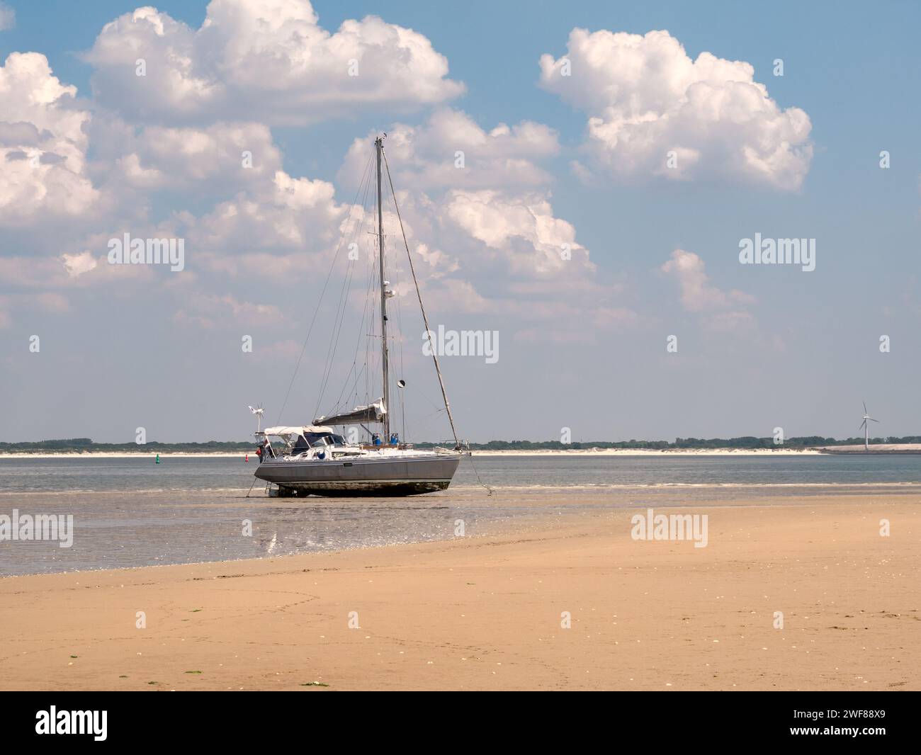 Sailboat dried out on tidal flats at low tide, Kwade Hoek nature reserve, Slijkgat tidal inlet, Netherlands Stock Photo