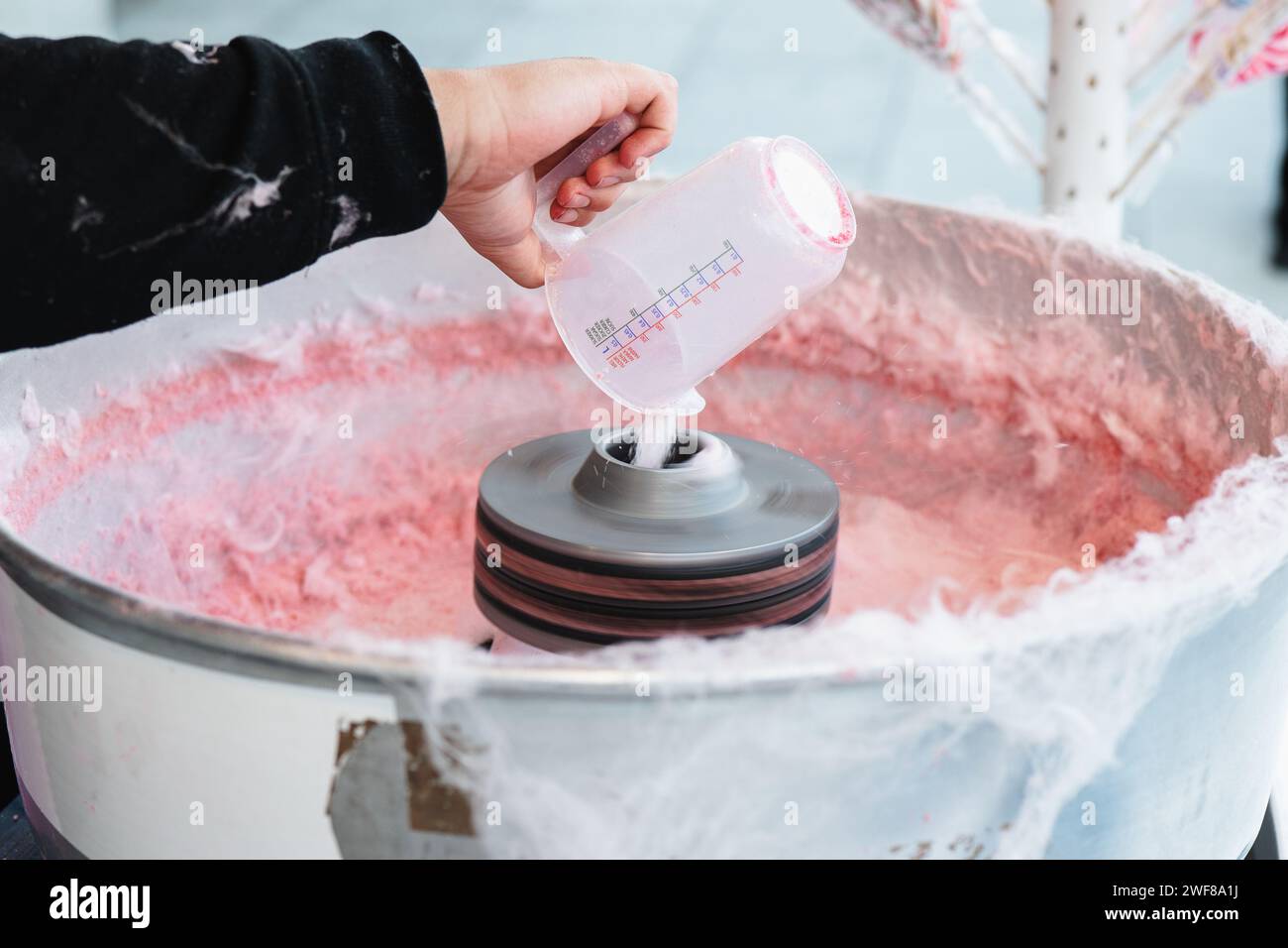 Close-up of a cropped unrecognizable hand pouring sugar into a cotton ...