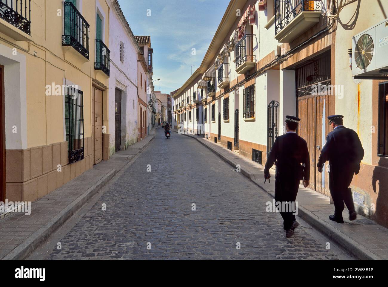 Policemen walking cobblestone street in Daimiel, Castille La Mancha, Spain Stock Photo