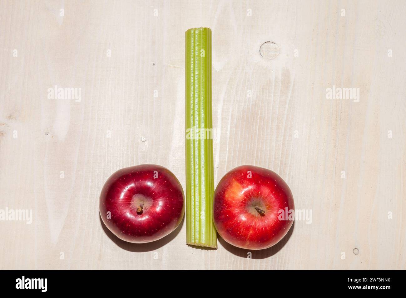 apples and celery arranged on wooden background Stock Photo