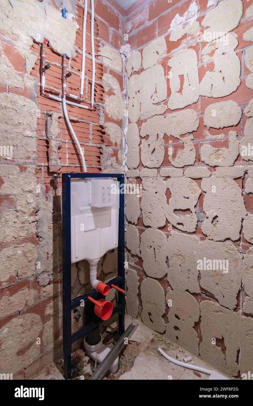 Installation of a wall-mounted toilet in a bathroom renovation with ...