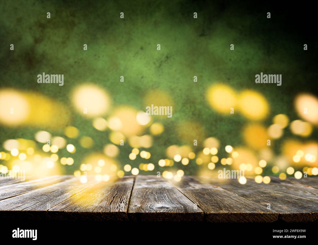 Happy St. Patricks Day background. Abstract green background with empty wooden table and glitter lights background. St. Patricks Day holidays wallpape Stock Photo