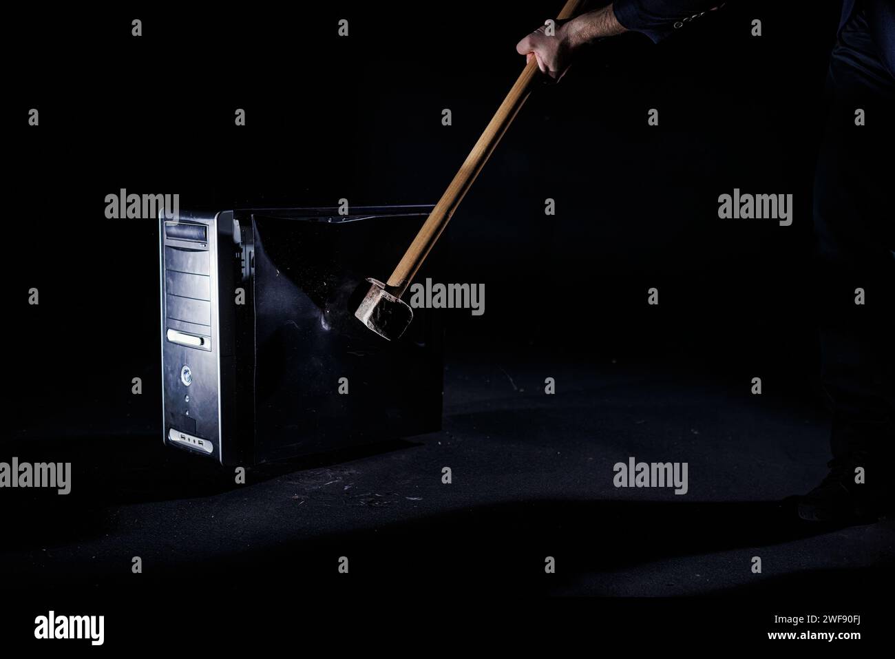 Human hands holding a sledgehammer and destroying a PC with a hard blow ...