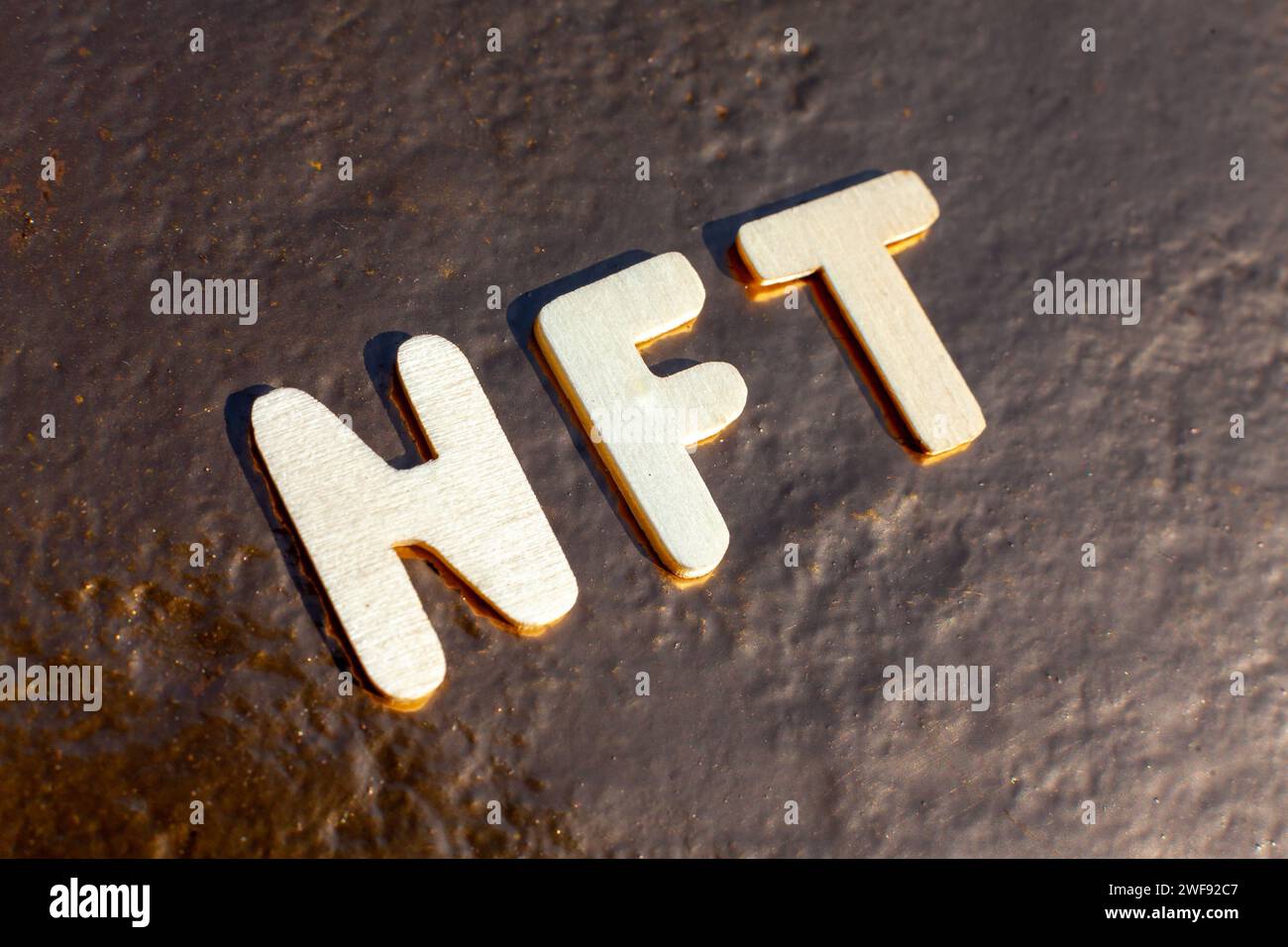 wooden nft letters on golden background Stock Photo - Alamy