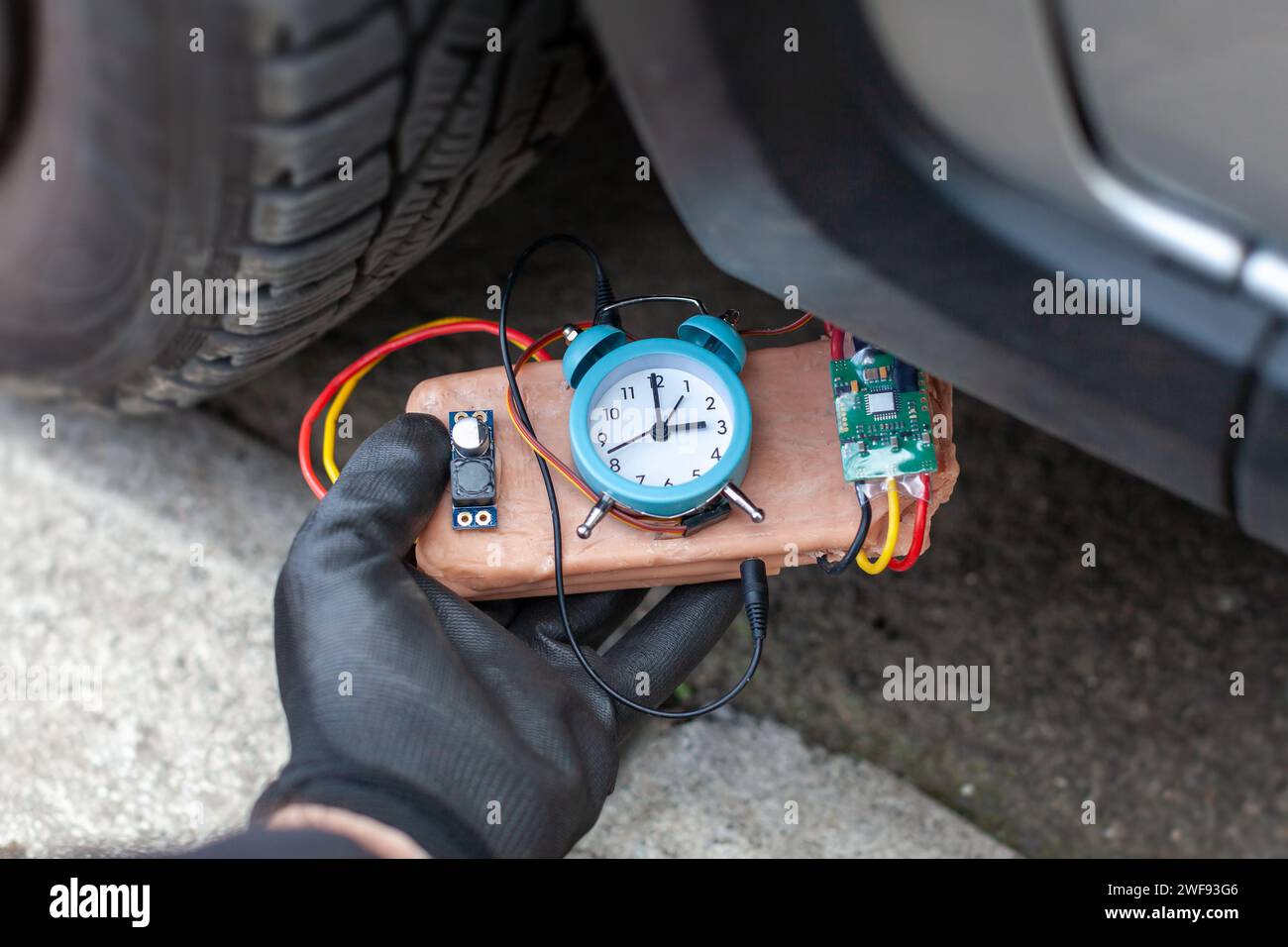 terrorist placing a time bomb under vehicle Stock Photo