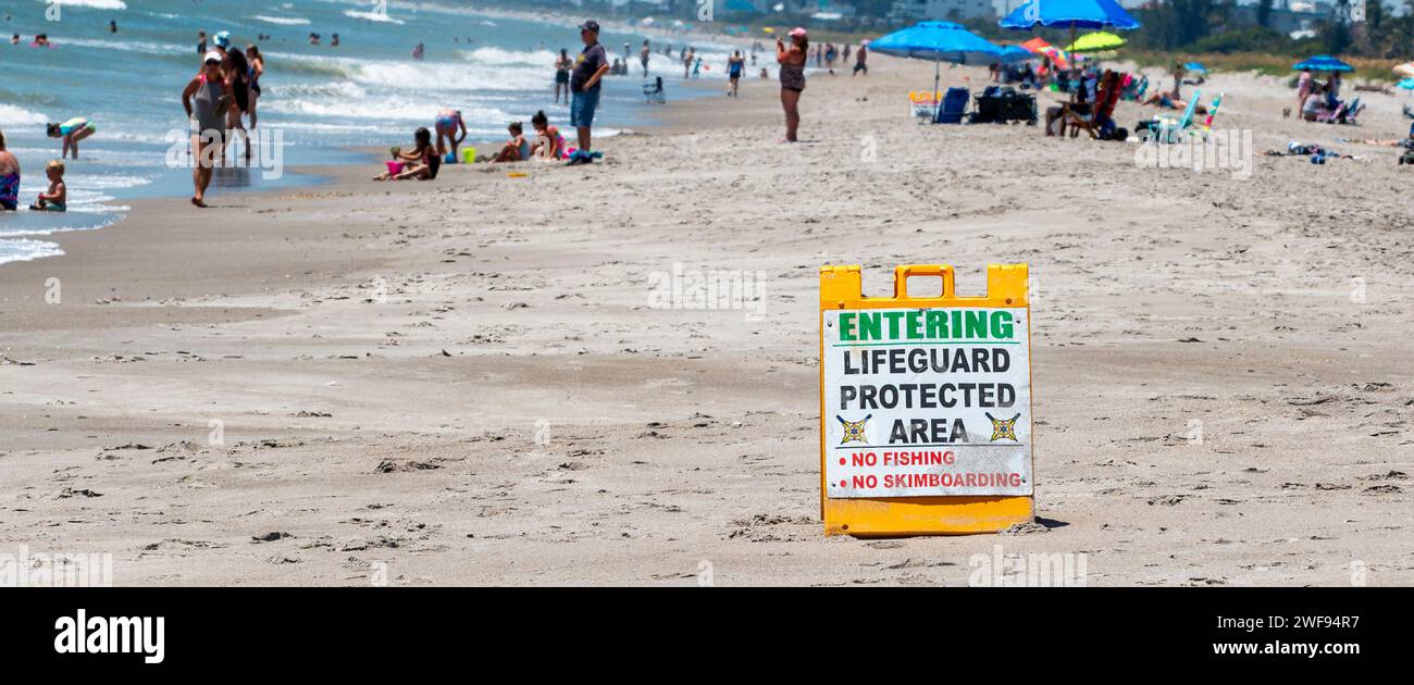 Cocoa Beach, Florida, USA - 27 June 2023: A picturesque scene of a serene beach with a vibrant sign that warmly welcomes visitors to a lifeguard prote Stock Photo