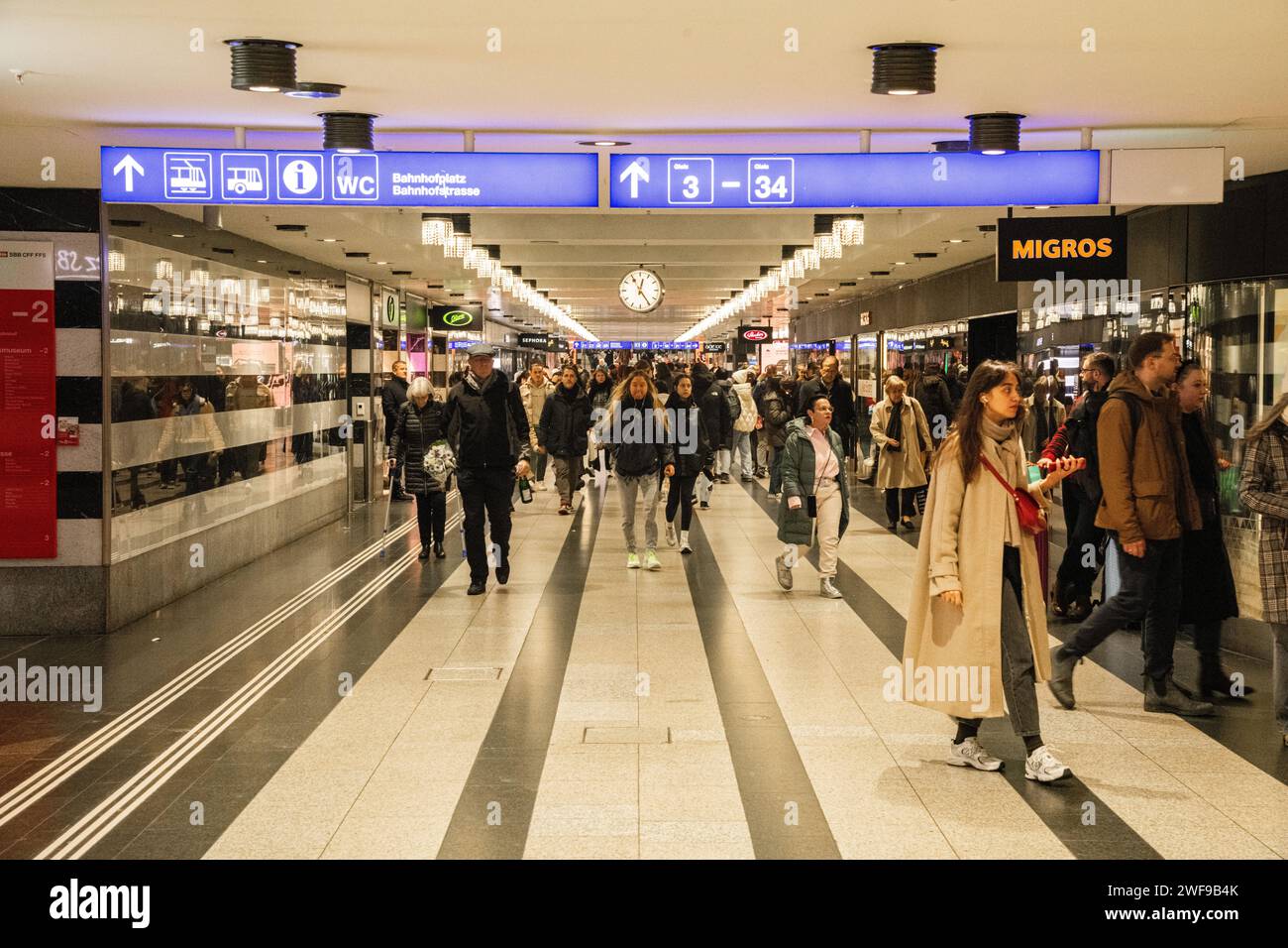 People, tourists, and commuters walking through a concourse at Zurich Hauptbahnhof in Zurich, Switzerland Stock Photo