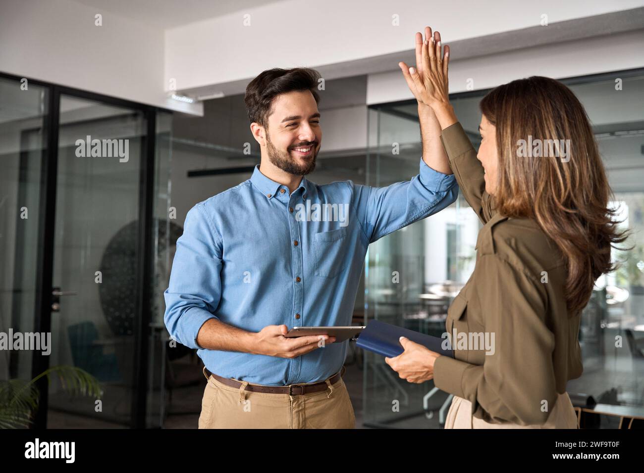 Two business executives giving high fives Stock Photo - Alamy