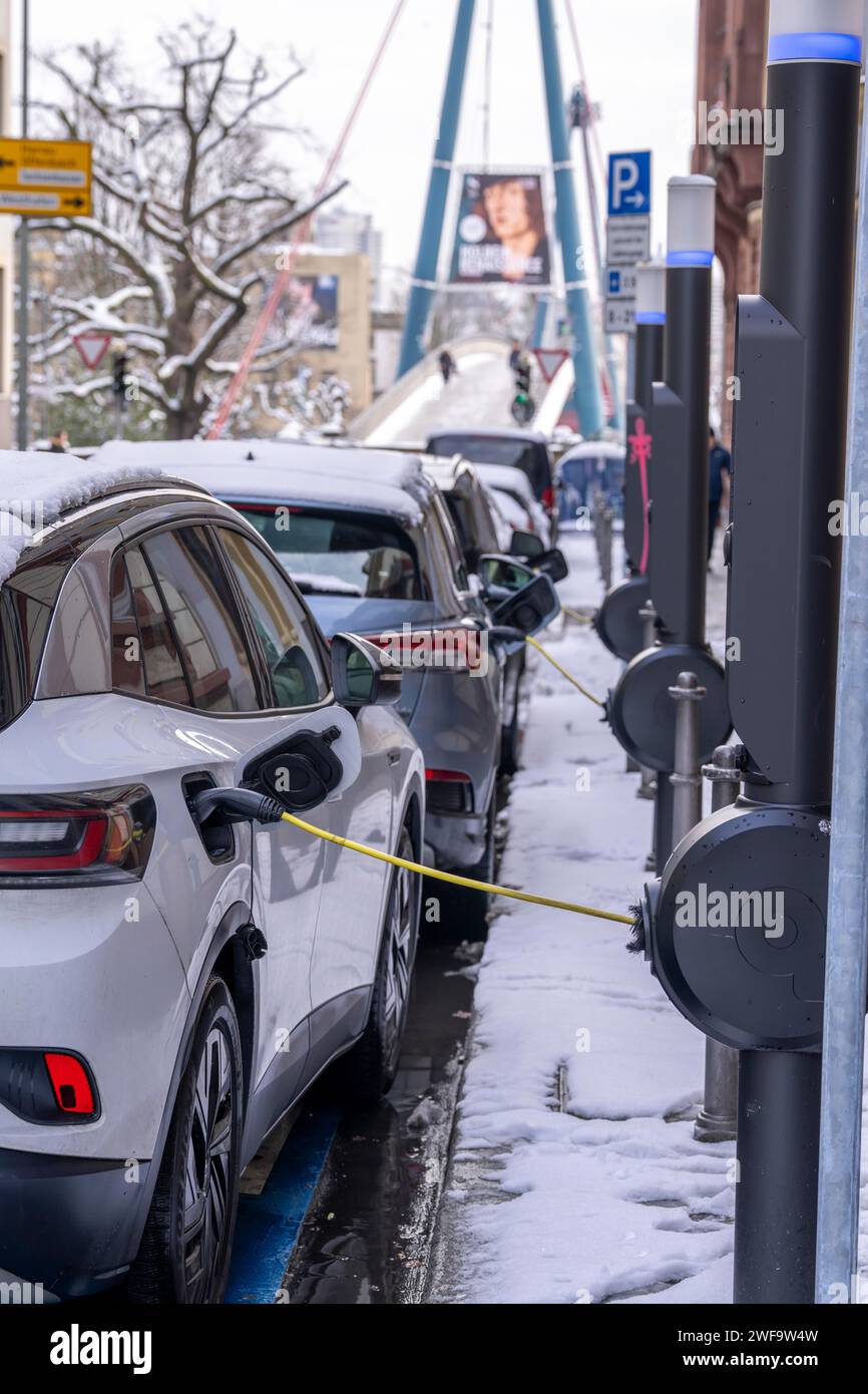 Winter in the city, electric cars charging at charging stations in the city center of Frankfurt, Hesse, Germany Stock Photo